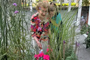 Résidente et membre de l'équipe KELA en train de rigoler lors d'une activité jardinage à la résidence Hardoy