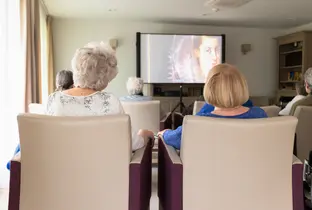Résidentes regardant un documentaire dans le salon polyvalente à la résidence Rubens