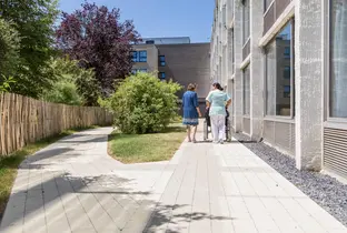 Résident, collaboratrice et famille marchant à l'extérieur de la résidence L'Adret