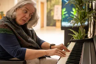 Résidente jouant du piano à la résidence Carina dans le cadre du projet Living