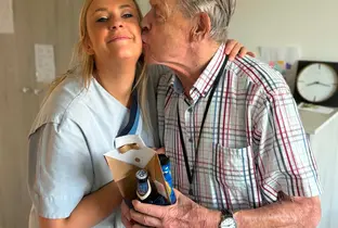 Aide soignante offre un cadeau à un résident à l'occasion de la fête des pères (27-08-26)