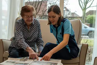 Résidente et membre de l'équipe KEL en train de lire un journal dans le cadre du projet Living à la résidence Ter Eyke