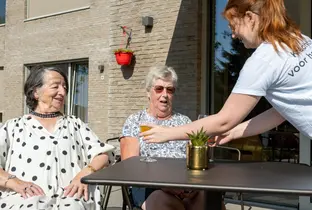 Aide-Soignante apportant un apéritif à deux habitantes de la résidence Pitthem AW