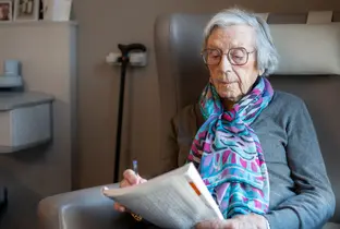 Résidente faisant ses mots croisés à la résidence Prinsenhof dans le cadre du projet Living