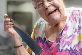 Résidente grimaçant en tenant un couteau de cuisine à la résidence Saint-François dans le cadre du projet Living