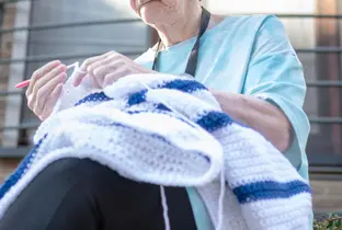 Résidente faisant du crochet à la résidence Senior Westland dans le cadre du projet Living