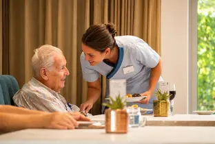 Infirmière donnant à son repas à l'un des habitants de la résidence Pitthem AW