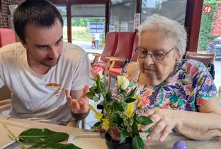 Résidente et membre du personnel lors d'un atelier floral à la résidence Le Thines
