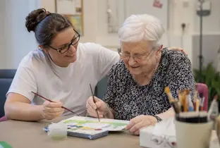 Membre du personnel et résidente durant une activité peinture au sein d'une unité spécialisée