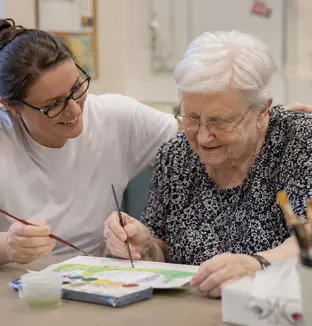 Membre du personnel et résidente durant une activité peinture au sein d'une unité spécialisée