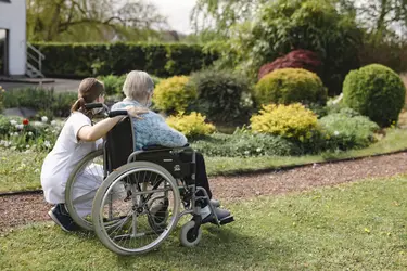 Kiné et résident se promenant dans le jardin de la résidence Les Amarantes