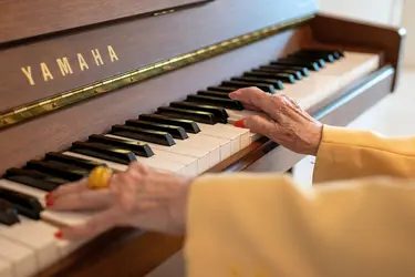 Mains d'une habitante jouant du piano à la résidence Argenteuil