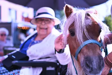 Résidente caressant un poney dans le cadre d'une activité à la résidence Boschart