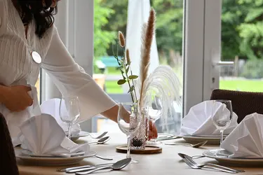 Préparation d'une table du restaurant de la résidence Augustin
