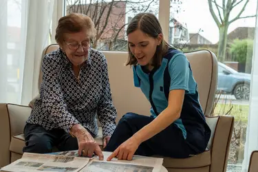Résidente et membre de l'équipe KEL en train de lire un journal dans le cadre du projet Living à la résidence Ter Eyke