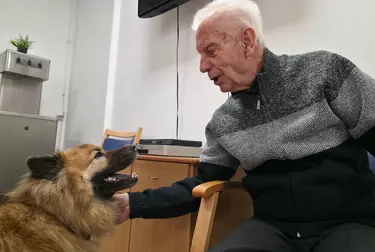 Résident caressant un chien à la résidence Carina